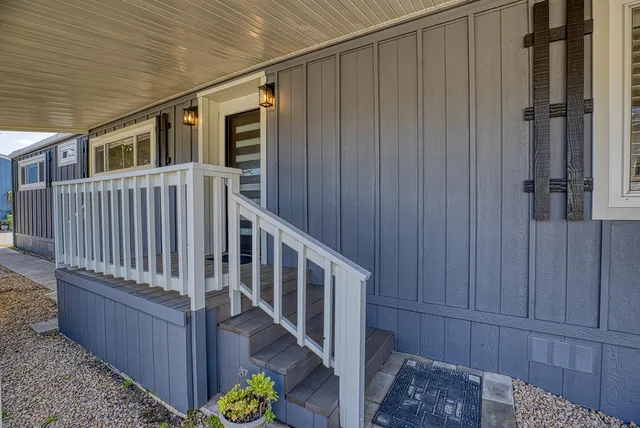 a view of an empty room with wooden floor and windows