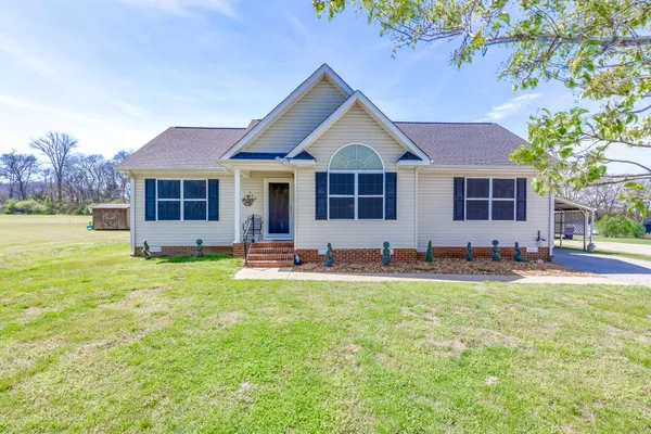 a front view of a house with a yard and trees
