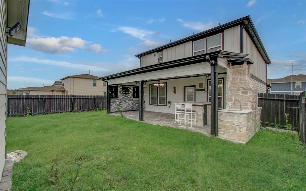 4627 Prairie Chase Drive Houston, TX 77069 - Photo 22 of 23 Sleek modern backyard with covered patio, stone accents, and a built-in outdoor bar — perfect for entertaining.