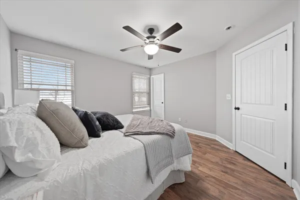 a bedroom with a large bed and a ceiling fan
