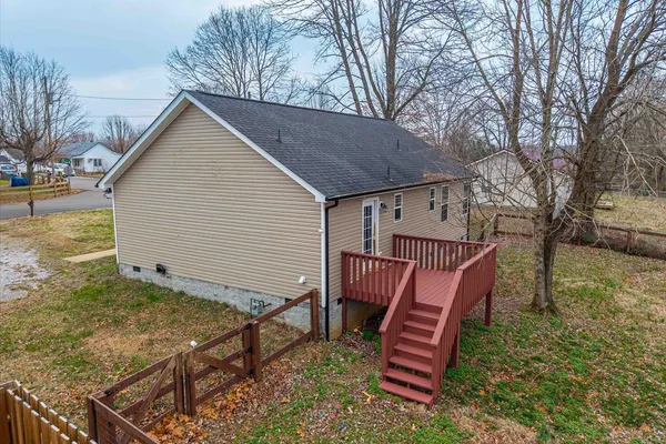 a view of a house with a yard chairs and wooden fence