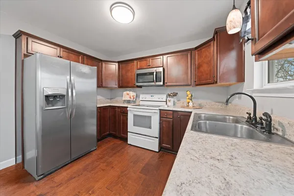a kitchen with stainless steel appliances granite countertop a refrigerator sink and microwave