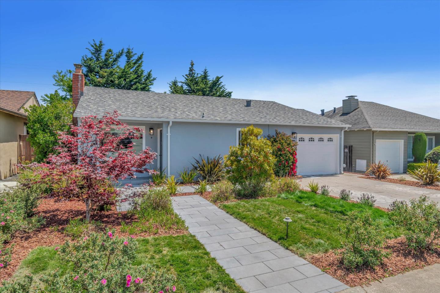 a front view of a house with a garden