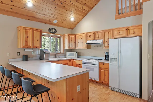 a large kitchen with stainless steel appliances granite countertop a sink and a window