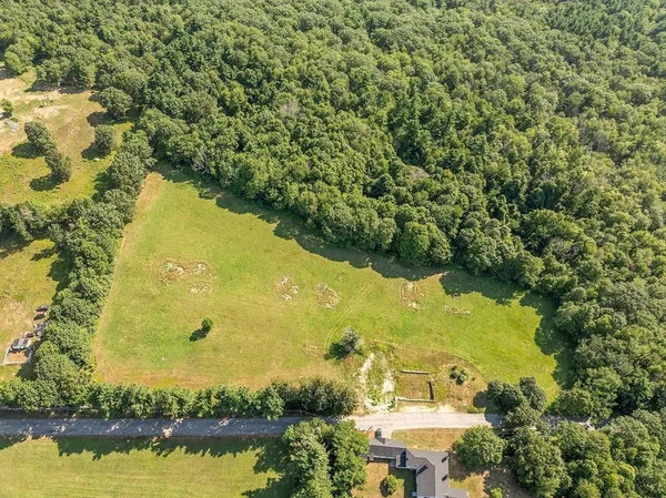 an aerial view of residential houses with outdoor space and swimming pool