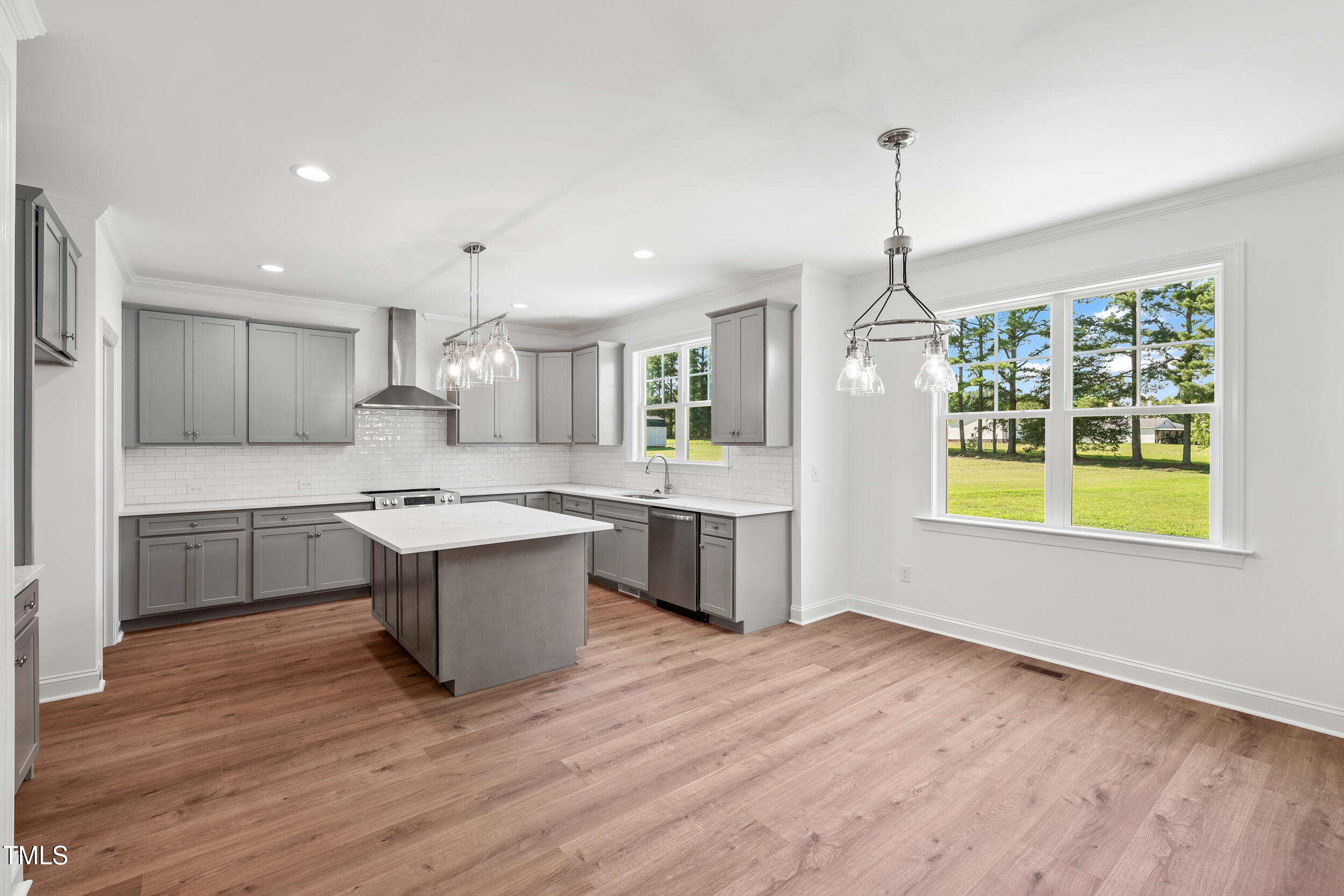 1693 Will Suitt Road Butner, NC 27522 - Photo 18 of 41 a large kitchen with kitchen island a stove a sink a center island and wooden floor