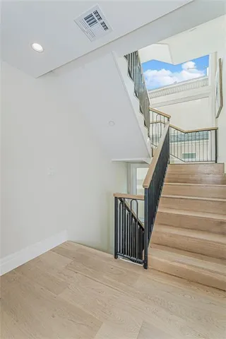 a view of staircase with lots of frames on wall and a window