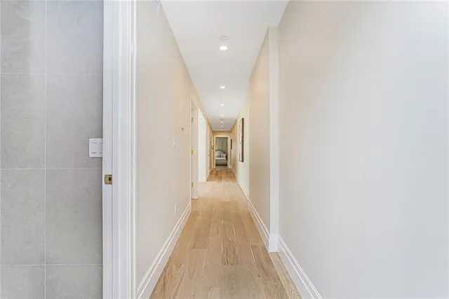 a view of a hallway with wooden floor and staircase