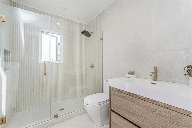 a bathroom with a sink a toilet and shower