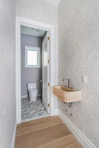 a bathroom with a sink a toilet and a mirror