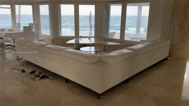 a living room with furniture and large windows