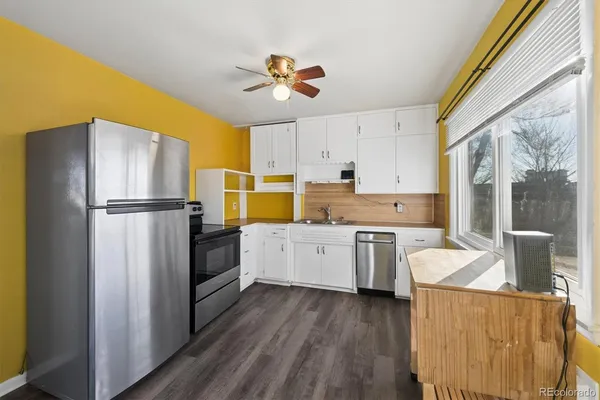 a kitchen with a refrigerator cabinets and wooden floor