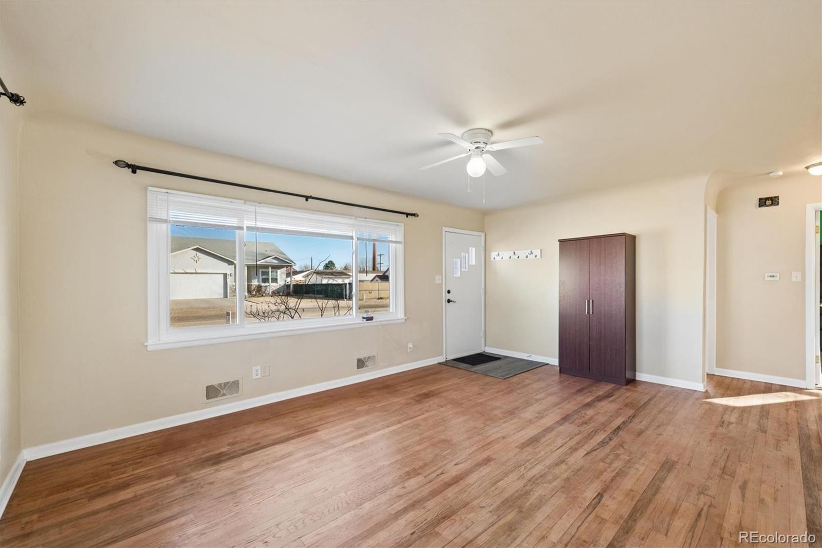 404 10th Street Gilcrest, CO 80623 - Photo 4 of 18 a view of an empty room with window and wooden floor