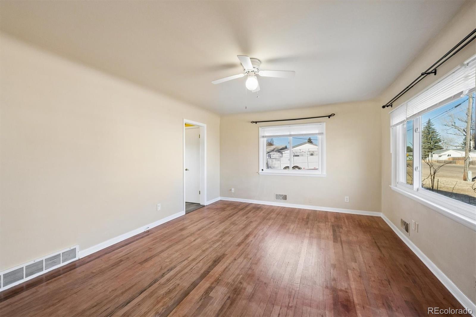 404 10th Street Gilcrest, CO 80623 - Photo 6 of 18 wooden floor in an empty room with a window