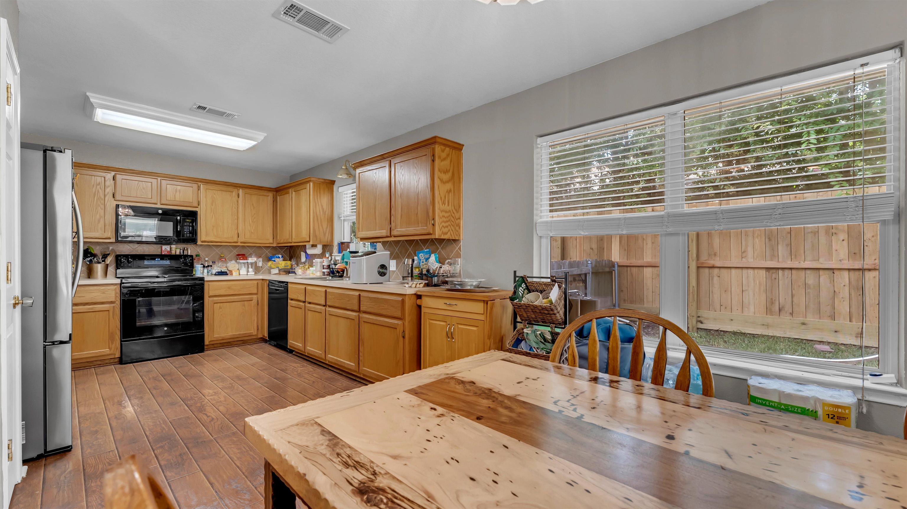 1004 East Johnson Street Burnet, TX 78611 - Photo 6 of 23 a kitchen with granite countertop a stove a sink a dining table and chairs