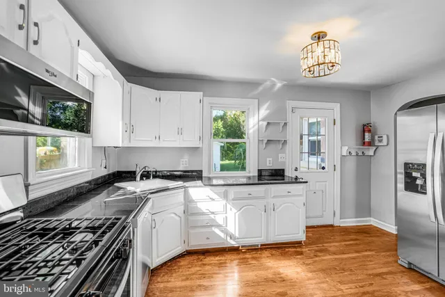 a kitchen with stainless steel appliances granite countertop a stove a sink and a microwave