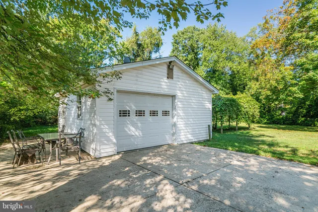a view of a house with a yard and lawn chairs under an umbrella