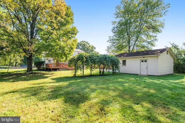 a view of a house with a big yard and large trees