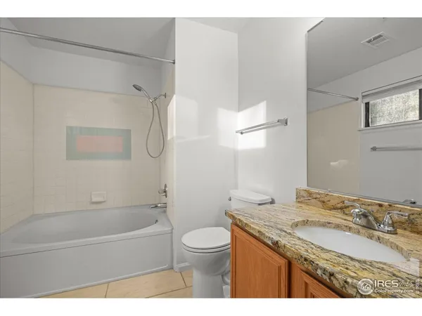 a bathroom with a granite countertop sink a toilet and shower