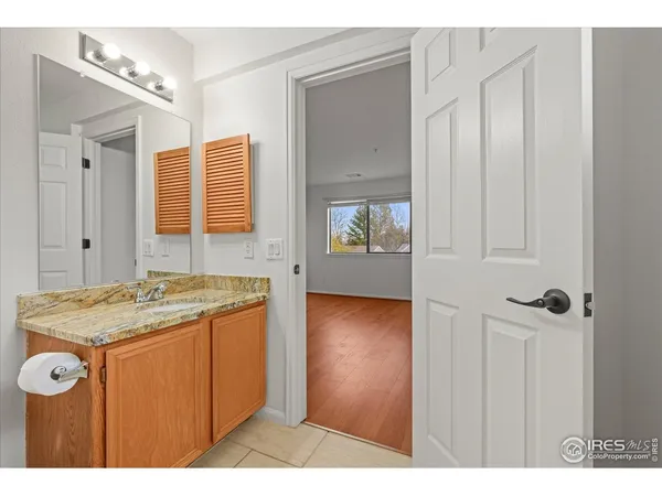a bathroom with a granite countertop sink a mirror and a shower