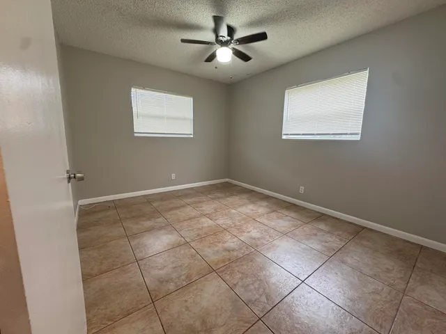 a view of an empty room with a ceiling fan and a window