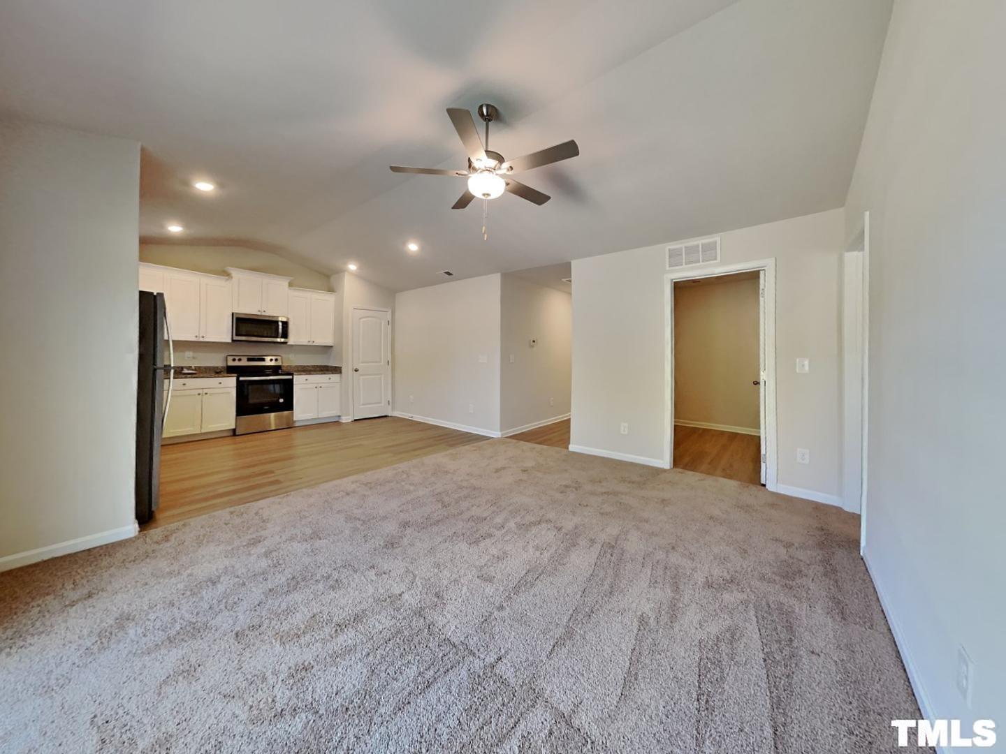 175 Coleshill Road Angier, NC 27501 - Photo 3 of 16 a view of a kitchen with kitchen island wooden floor and a ceiling fan