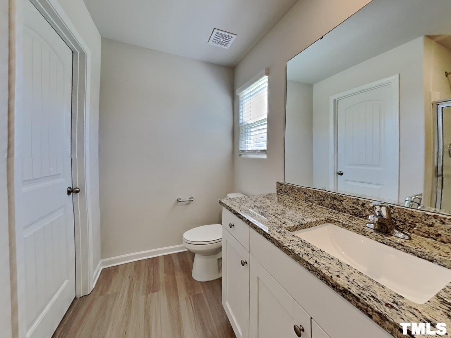175 Coleshill Road Angier, NC 27501 - Photo 10 of 16 a bathroom with a granite countertop sink a toilet and a window