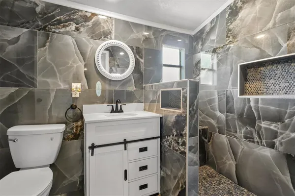 a bathroom with a toilet sink and mirror