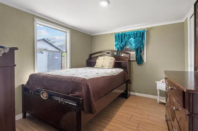a bedroom with a bed and wooden floor
