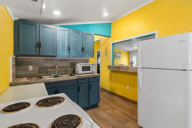 a kitchen with a sink a stove and a refrigerator