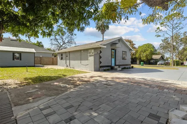 a view of a house with backyard and tree