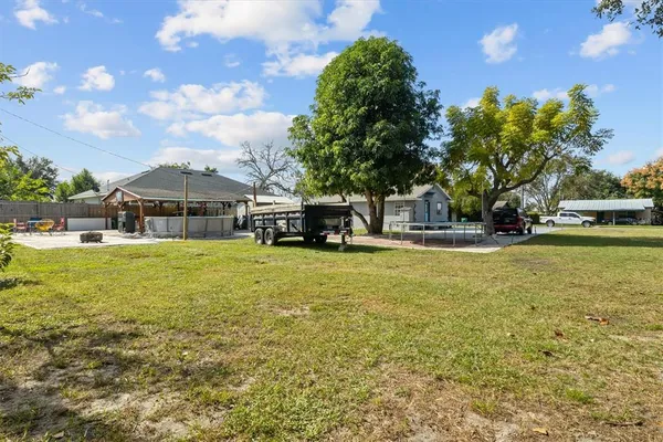 a house view with swimming pool and trees