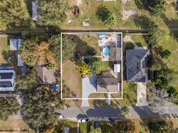 an aerial view of a house with a yard and large trees