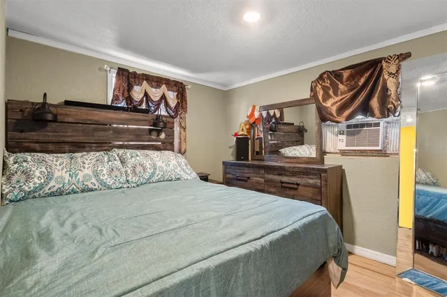 a bedroom with a bed and wooden floor