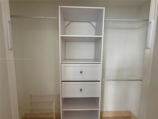 a view of walk in closet with white walls