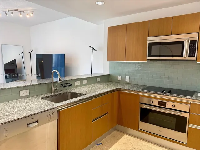 a kitchen with stainless steel appliances granite countertop a sink stove and microwave