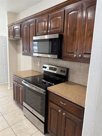 a kitchen with granite countertop a stove and a microwave