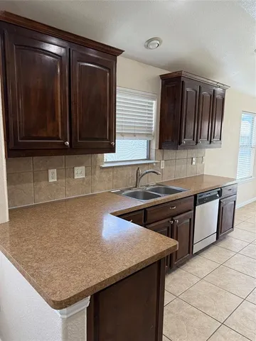 a kitchen with granite countertop a sink and a stove