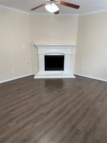a view of empty room with wooden floor and fireplace