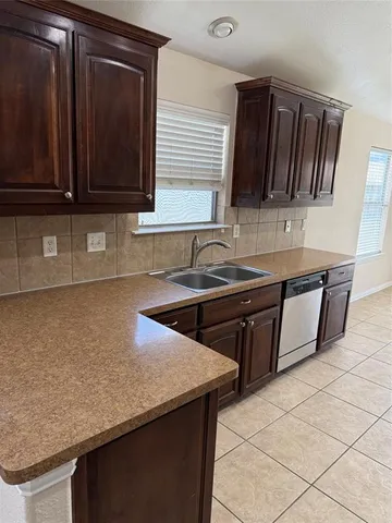 a kitchen with granite countertop a sink a stove and cabinets