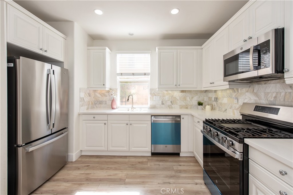 94 Chantilly Irvine, CA 92620 - Photo 9 of 30 a kitchen with stainless steel appliances granite countertop a refrigerator stove top oven and sink