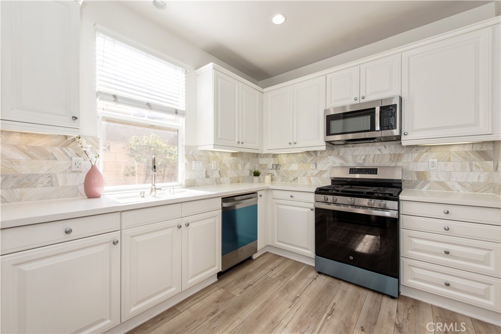 94 Chantilly Irvine, CA 92620 - Photo 10 of 30 a kitchen with cabinets stainless steel appliances a sink and a window