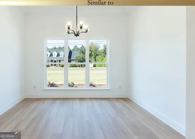 an empty room with wooden floor and outdoor view