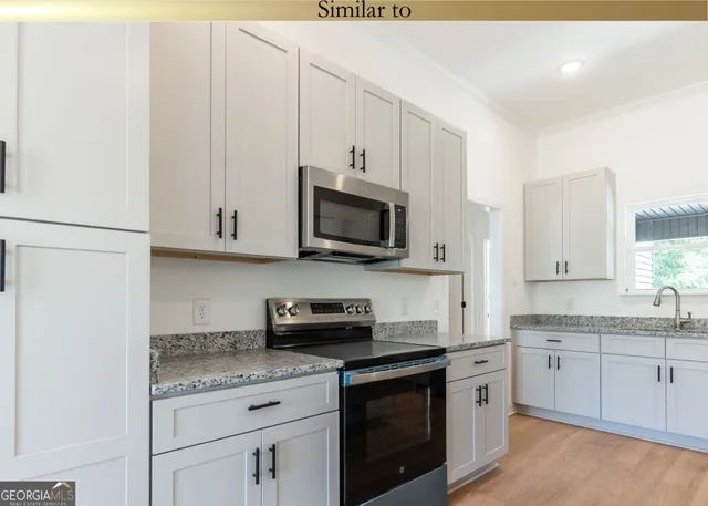 a kitchen with stainless steel appliances granite countertop a sink a stove a microwave and cabinets