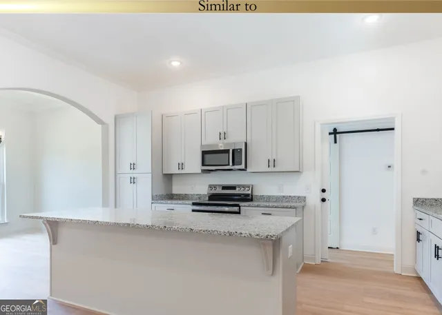 a kitchen with stainless steel appliances a stove a microwave a sink and cabinets