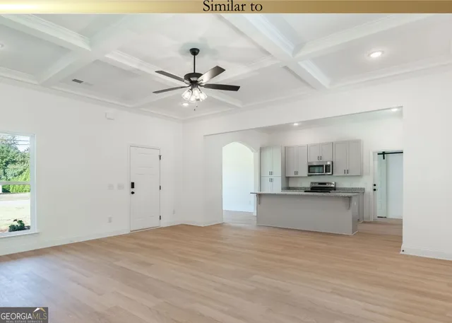 a large kitchen with stainless steel appliances a large counter top a chandelier and a view of kitchen