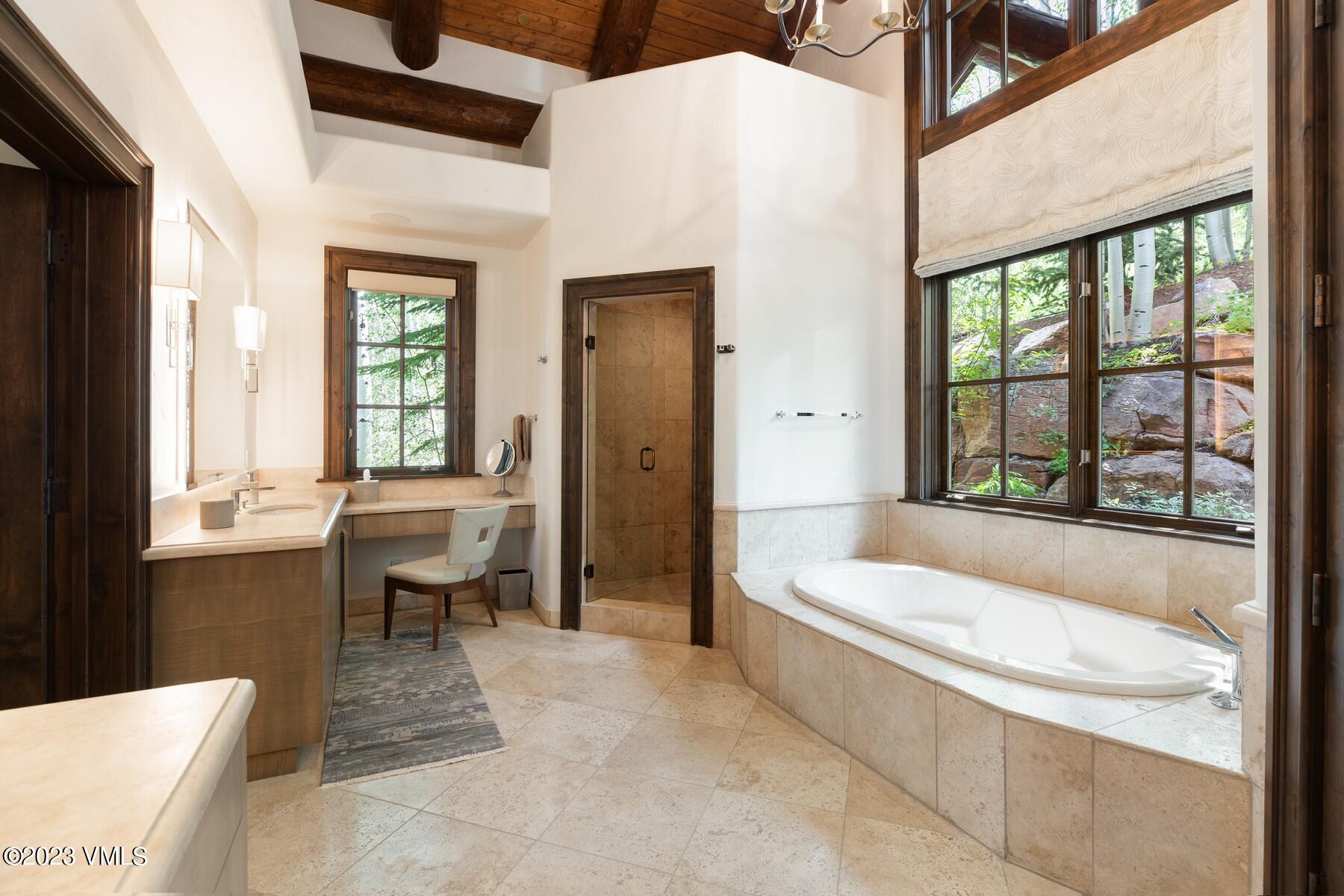 941 Daybreak Ridge Road Avon, CO 81620 - Photo 14 of 29 a bathroom with a granite countertop tub sink a toilet and a large window