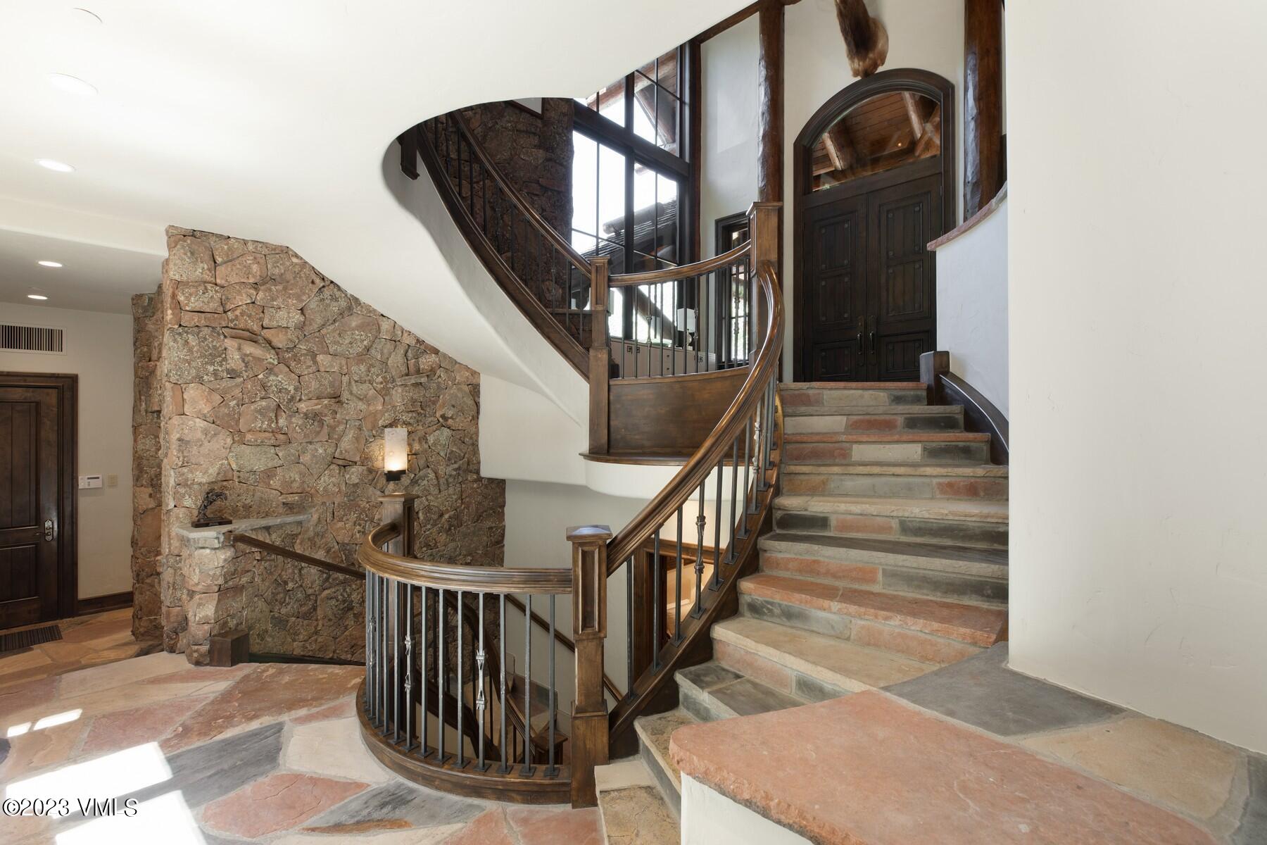 941 Daybreak Ridge Road Avon, CO 81620 - Photo 19 of 29 a view of staircase with railing and a chandelier
