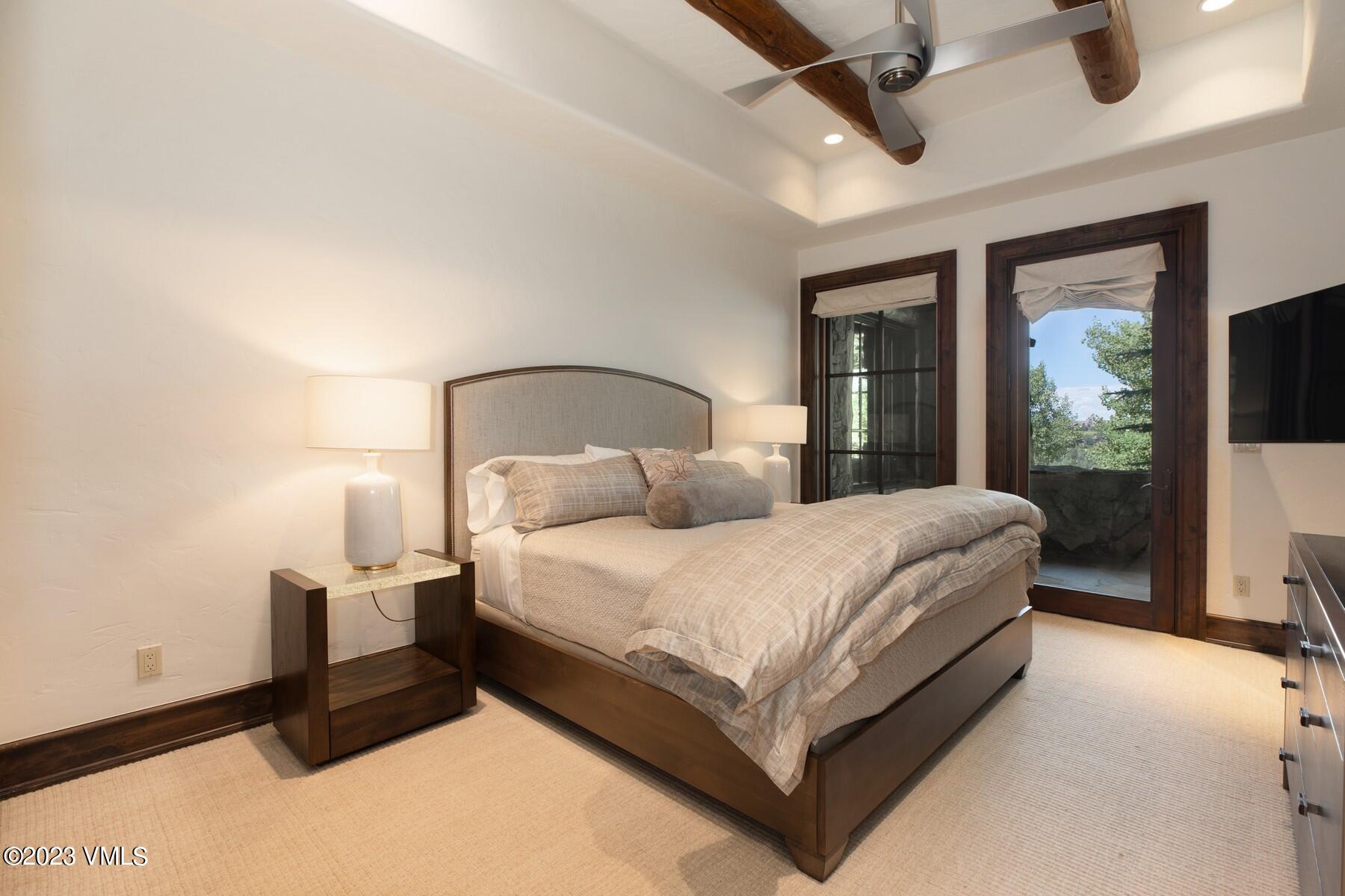 941 Daybreak Ridge Road Avon, CO 81620 - Photo 24 of 29 a bedroom with a bed lamp on desk and a large window