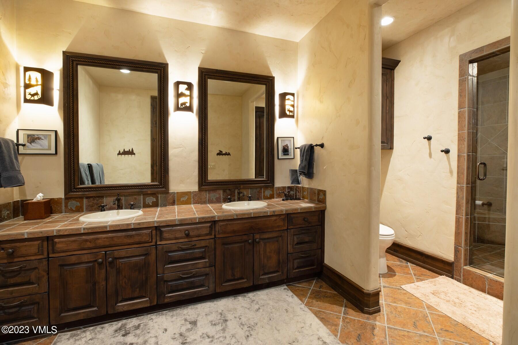 941 Daybreak Ridge Road Avon, CO 81620 - Photo 25 of 29 a spacious bathroom with a double vanity sink and a mirror